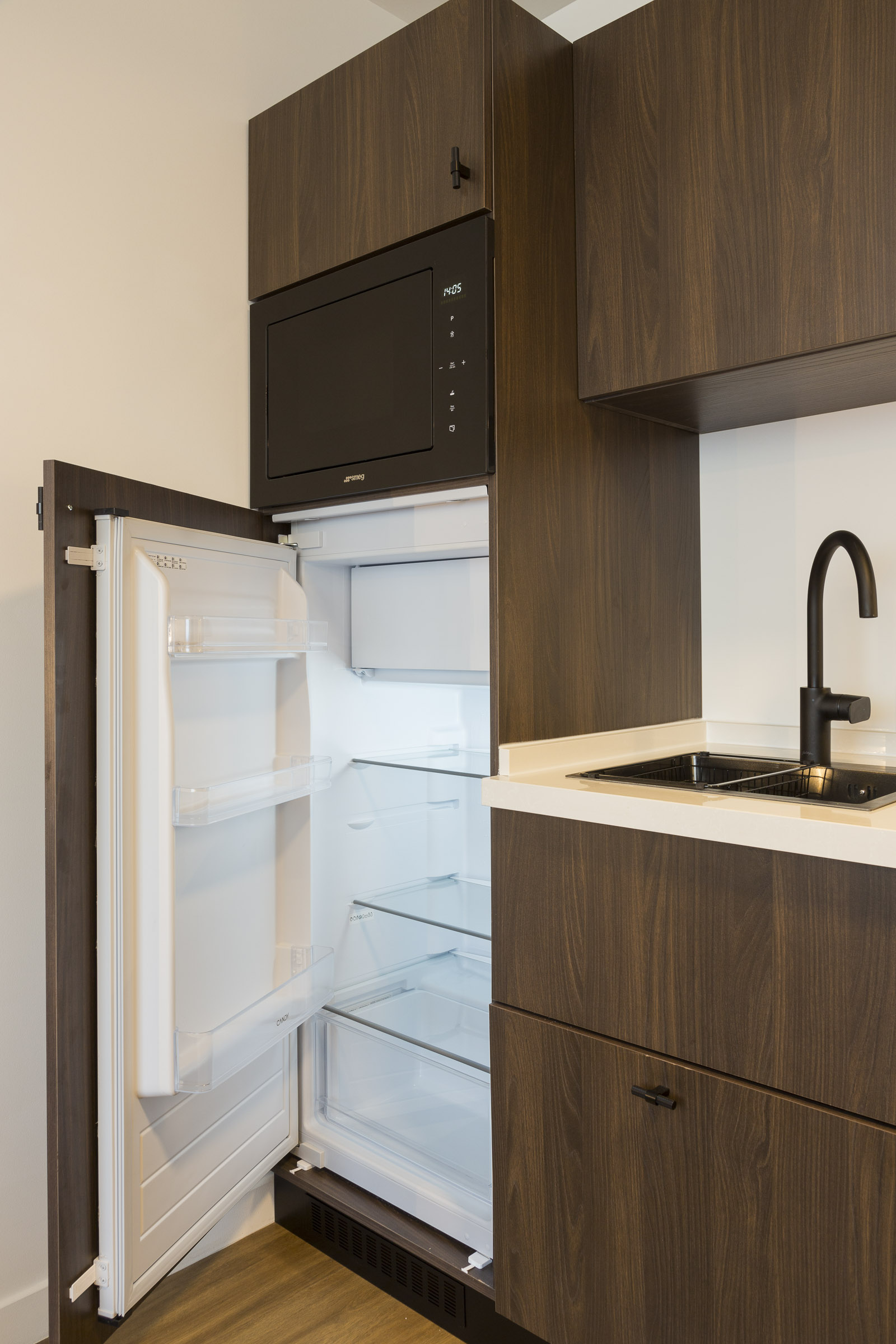 Cuisine avec grand réfrigérateur et four combiné d'un studio supérieur au Nehô Suites Saint-Jean-de-Maurienne.