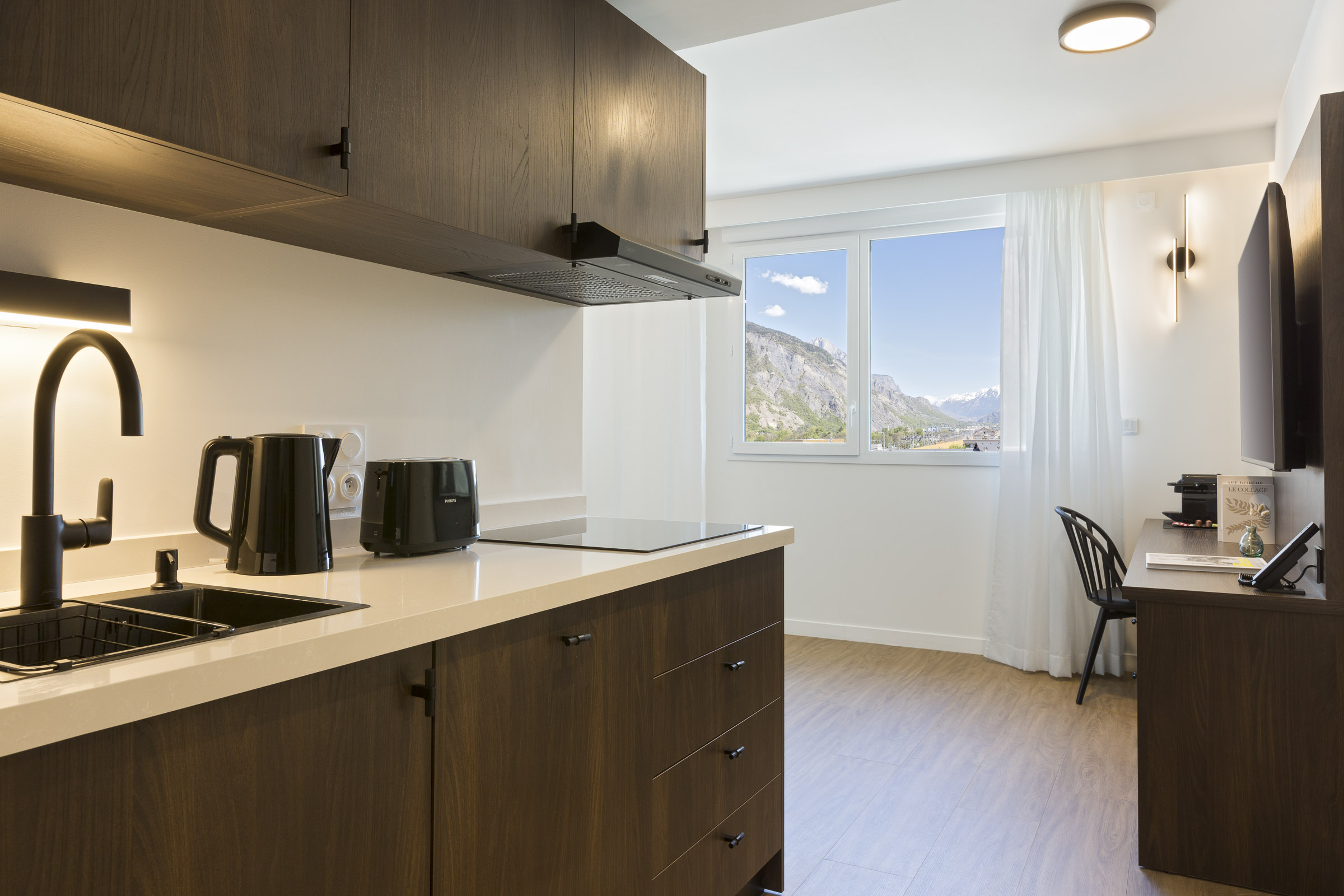 Appartement 2 pièces avec kitchenette, bureau, fenêtre et vue montagne au Nehô Suites Saint-Jean-de-Maurienne.